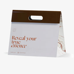 Weiße Geschenktüte Olfazeta by Chogan mit braunem Band, Aufschrift « Reveal your true essence » und marmorierter Seite