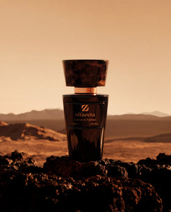 Flacon noir Olfazeta by Chogan Millésime N°22 sur roches volcaniques d'un désert au ciel ambré